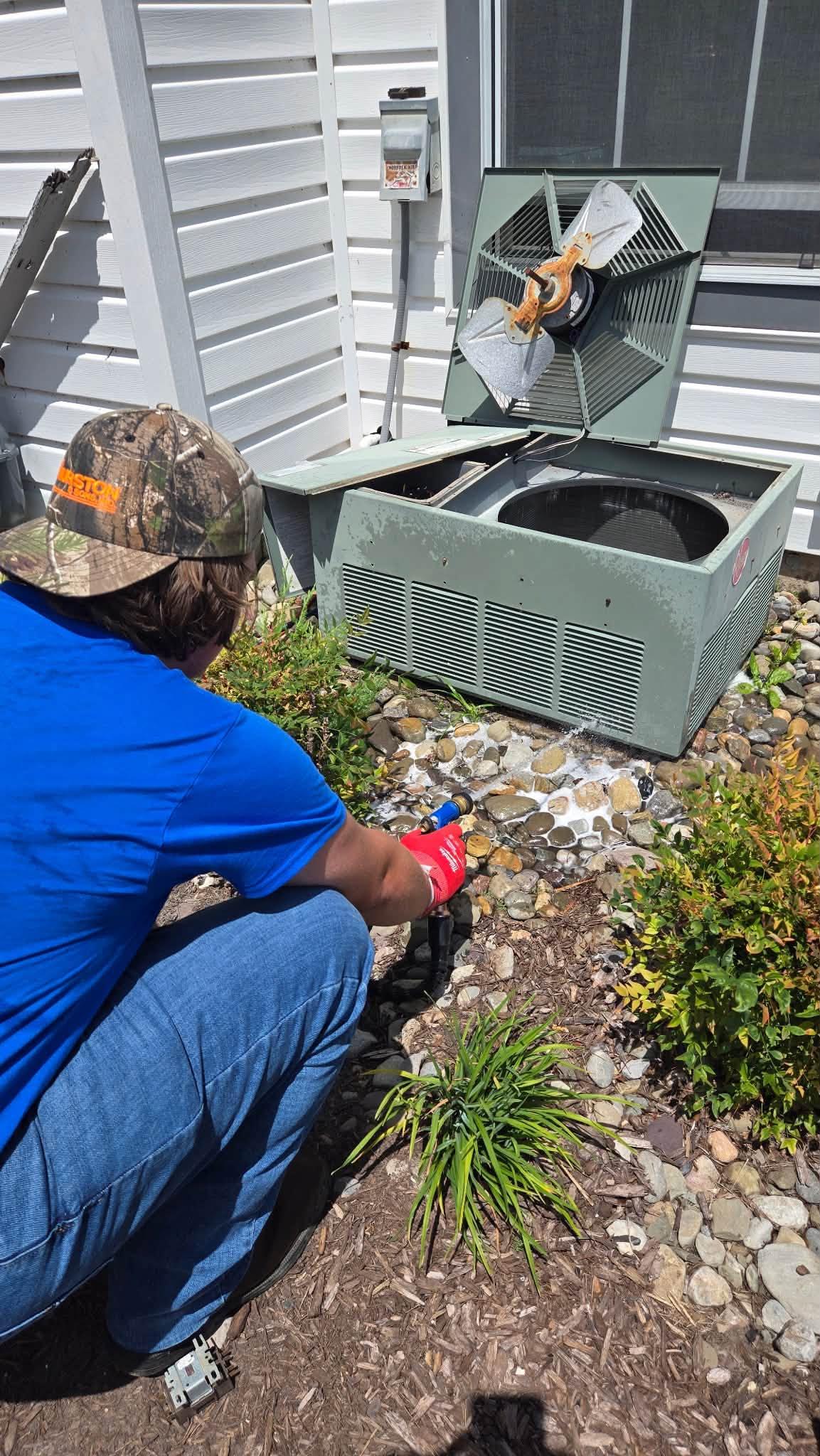 Ferguson & Sons technician servicing an outdoor HVAC unit